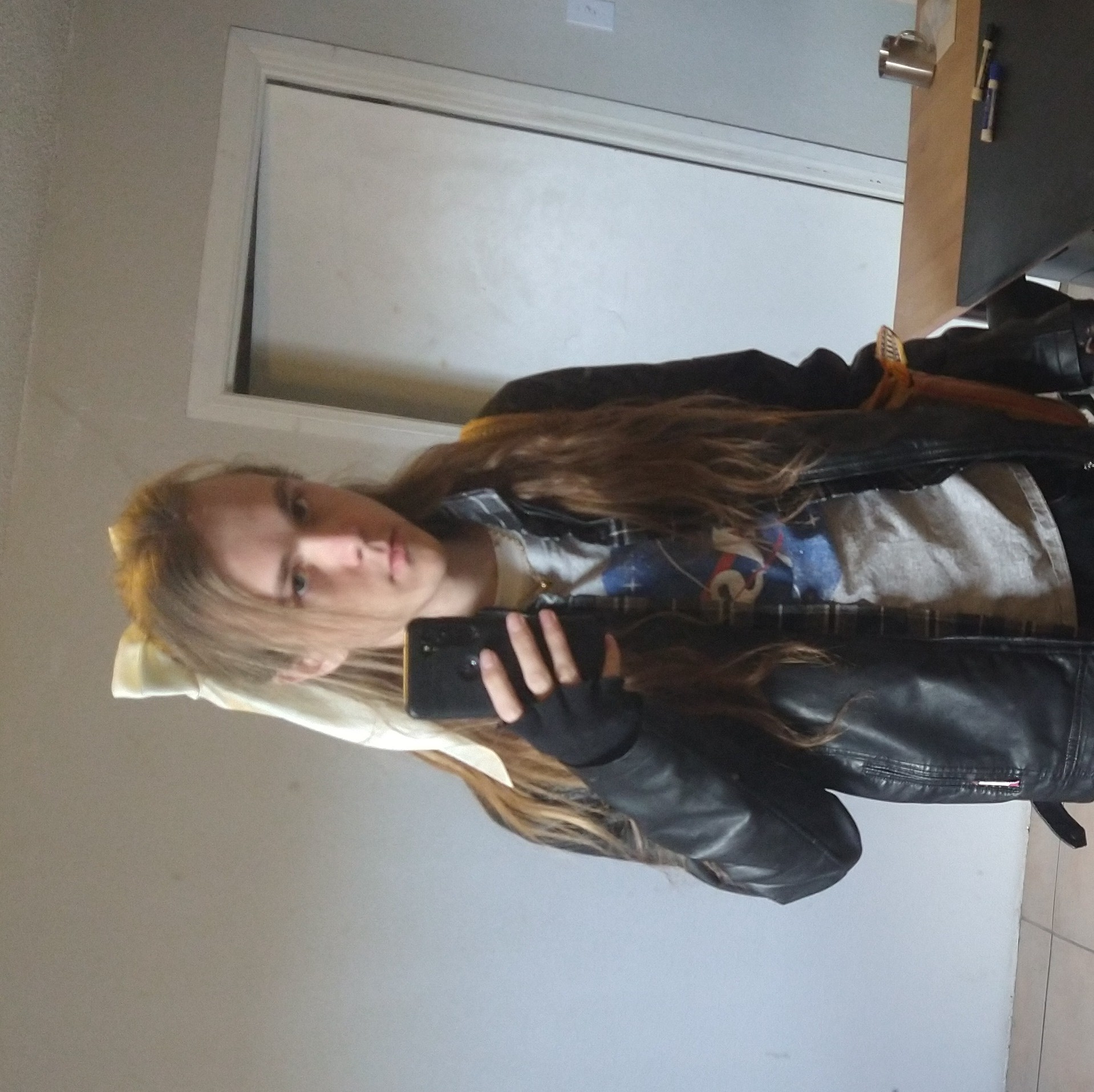 River, wearing a leather jacket, and taking a selfie in front of the mirror