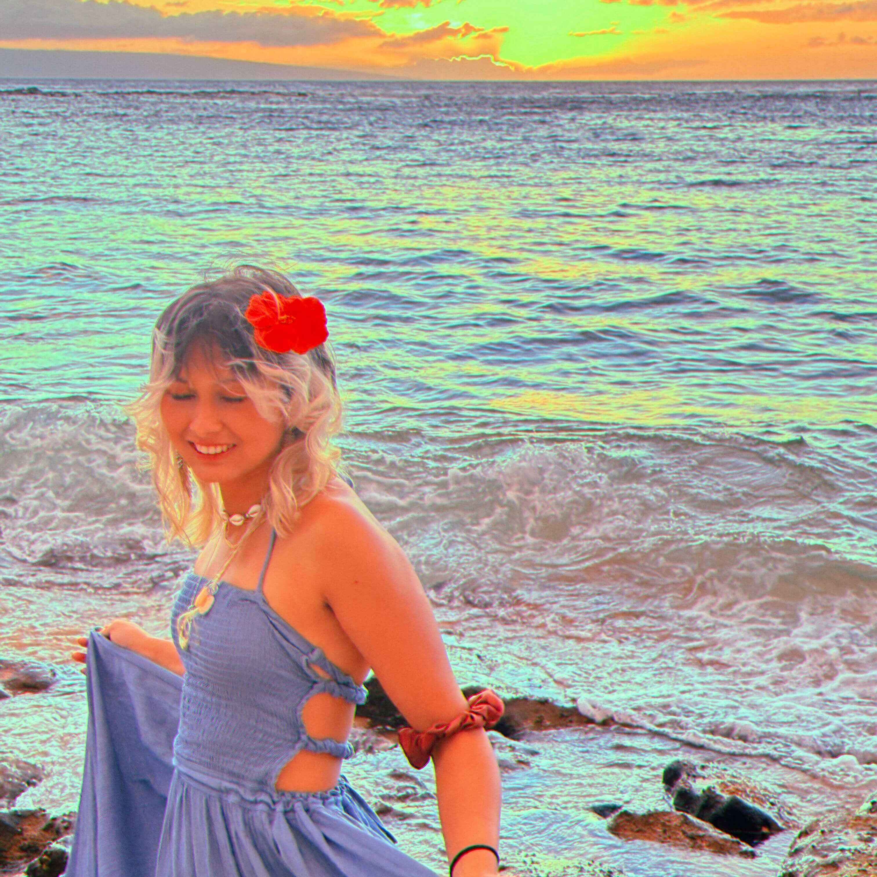 A photo of trish in Hawaii in front of a beach sunset
